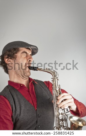 Ugly man wails on saxophone while dressed as a beatnik