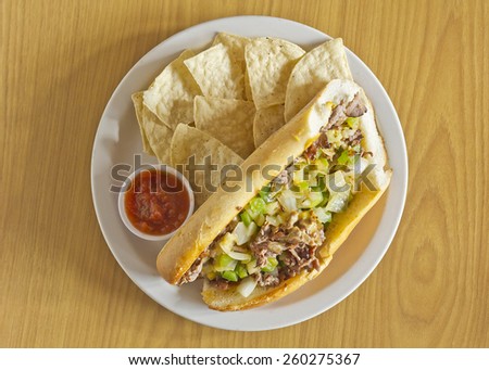 Philly Cheesesteak with diced onions peppers and mushrooms with tortilla chips and salsa on the side