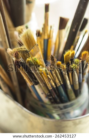 Container kit of assorted and stained old artist paintbrushes