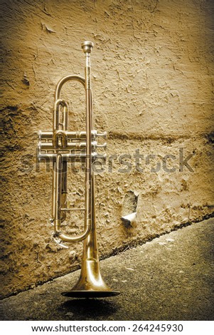 Old worn trumpet stands alone in alleyway behind a jazz club