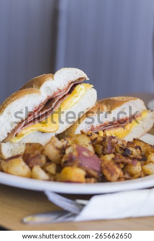 Taylor ham, pork roll, egg and cheese breakfast sandwich on a kaiser roll with salt pepper and ketchup and a side of home fries from New Jersey
