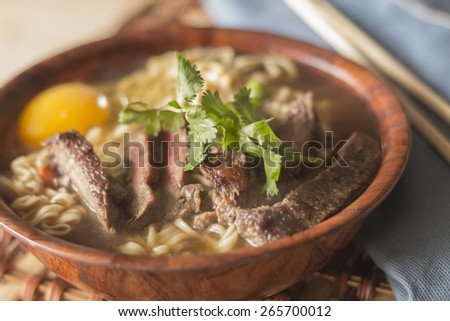 Beef ramen served Asian style. Raw egg cooks in steaming hot savory broth