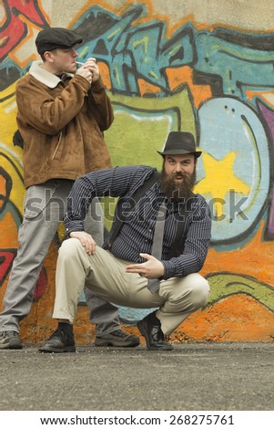 Two snazzy stylish men hang out on a street corner