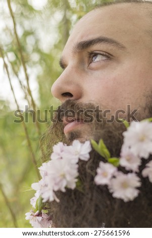 Flowers decorate the beard of this young man enjoying nature