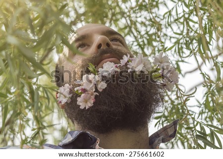 Flowers decorate the beard of this young man enjoying nature