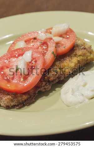Breaded cod fillet with tomato and onion with tartar sauce
