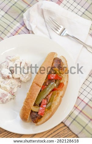 Fried sausage onions and red and green bell peppers on sandwich bun