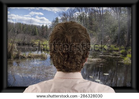 Back of man\'s head as he\'s watching flat screen television
