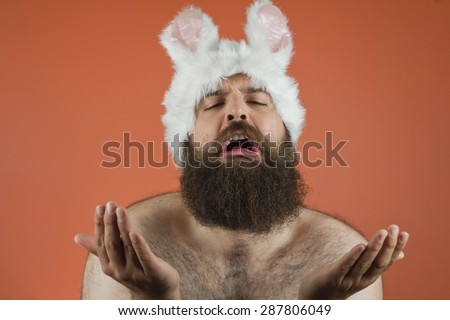 Pleading bearded fat man wears silly bunny ears