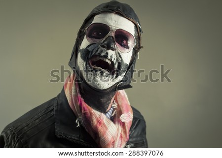 Scared aviator with face painted as human skull