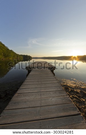 Long dock at dusk on calm and gentle lake in fisheye nature shot