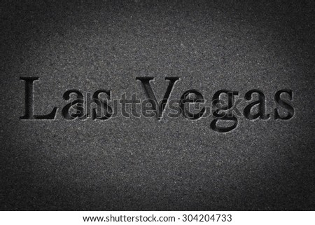 Engraving spelling the city Las Vegas on textured old surface