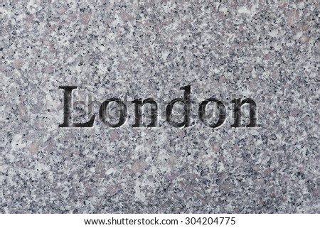 Engraving spelling the city London on textured old surface