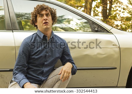 Silly man makes angry annoyed facial expression about dame to his car