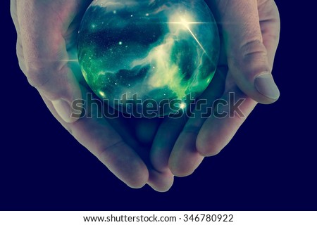 Holding the universe in fortune teller magic crystal ball