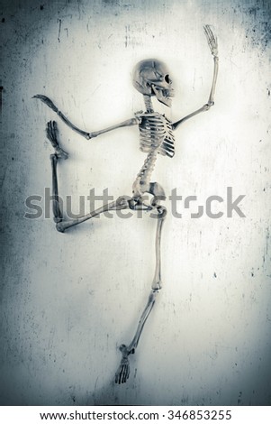 Silly dancing medical skeleton on grunge vintage background