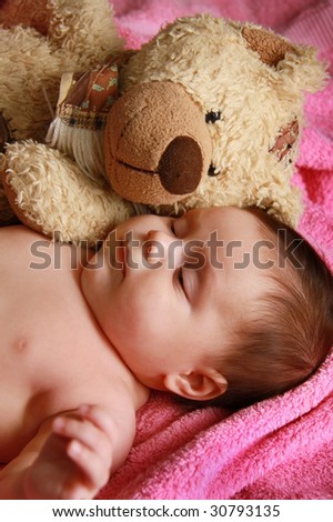 Two monthly child , sleeping with a plush toy