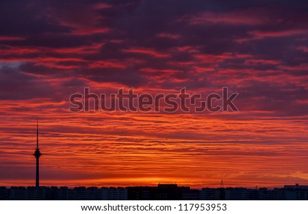 High television tower and orange gold red sky above sleeping city