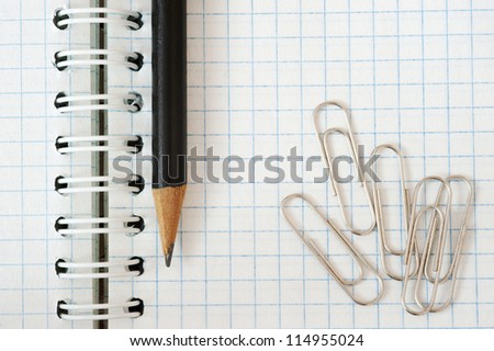 Notebook, pencil and paper clip