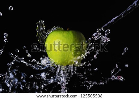 Green apple water splash on black background