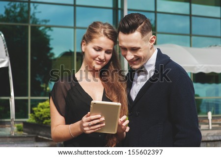Young beautiful woman and man looking at tablet pc