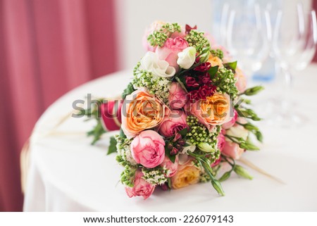 bridal bouquet of roses, buttercups and other flowers on the table