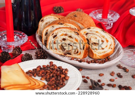 delicious cake on New Year\'s table with red candles and pine cones still life