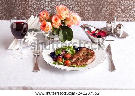 beautiful zaservirovannye meat with vegetables and sauce with berries in still life