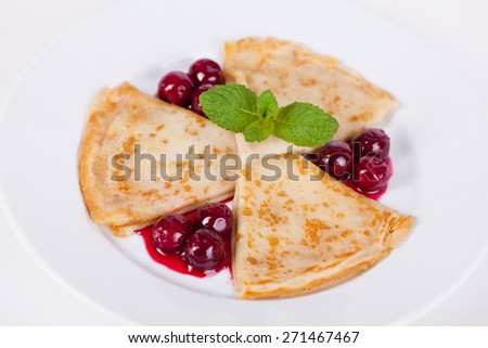 pancakes with cherry sauce and mint on a plate on a white background for cafe menu restaurant snack dessert