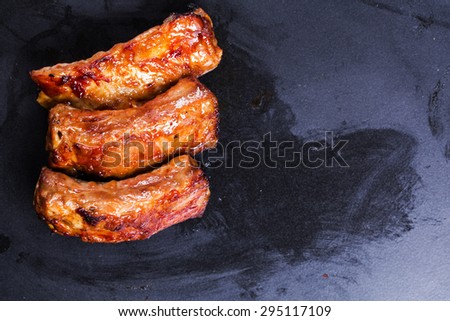 baked ribs isolated on black background in a sauce barbecue grill