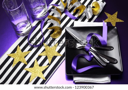 Football celebration party table in team colors decorations of  black, purple, gold and white.