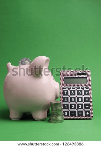 Savings and Shopping Sale concept with piggy bank, stack of coins and calculator against a green background.