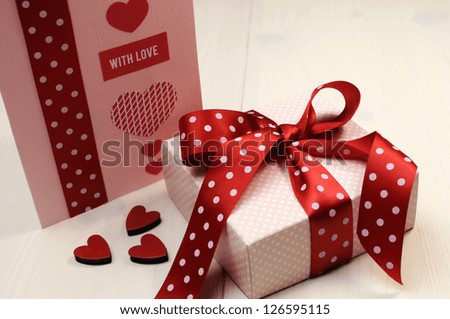 Special occasion handmade gift card, \'with love\' message, with pink gift and red polka dot ribbon and heart on white natural wood table, for Valentine, Christmas, Easter, birthday, or Mothers Day.