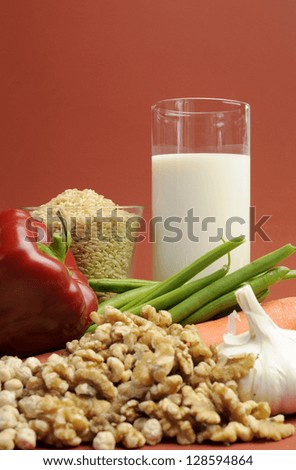 Low GI Foods - milk, brown rice, oatmeal, red capsicum pepper, green beans, garlic, raw carrot, walnuts, chickpeas, wholemeal pasta and buckwheat noodles. Vertical with copy space.