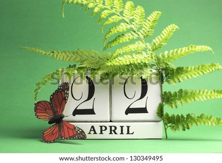 Earth Day, save the date white block calendar, April 22, with butterfly and ferns against a green background.