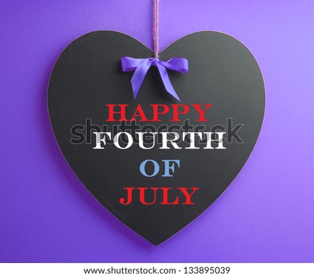 Fourth of July, USA America holiday celebration with Happy Fourth of July message greeting on heart shape blackboard in red, white and blue colors.