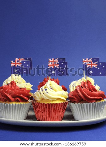 Australian theme red, white and blue cupcakes with national flag for Australia Day, Anzac Day or national holiday against a blue background. Vertical with copy space.