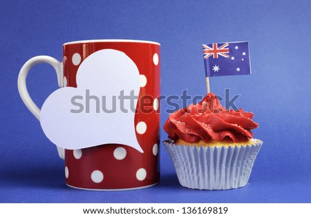 Australian theme red, white and blue cupcake with national flag and red polka dot coffee mug and white heart tag for your text here, for Australia Day, Anzac Day or national holiday.