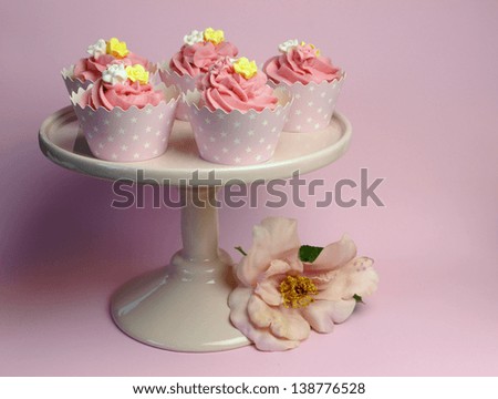 Beautiful pink decorated cupcakes on pink cake stand for birthday, wedding or female special event occasion.