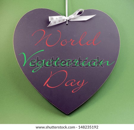 World Vegetarian Day message text written on heart shape blackboard on green background for October 1 event.