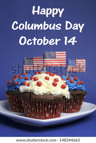 Happy Columbus Day for October 14 message and Red, White and Blue chocolate cupcakes with USA Stars & Stripes flags on blue background.