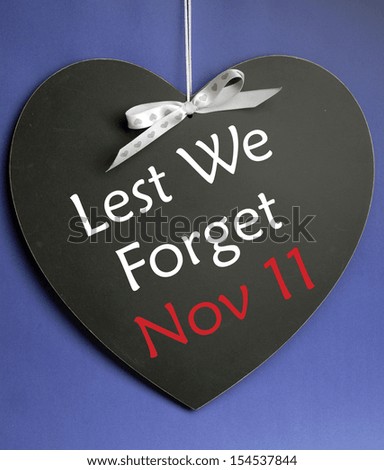 Lest We Forget message written on heart shape blackboard for Remembrance Day, Poppy Day, Armistice Day on November 11.