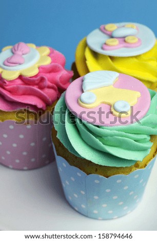 Beautiful pink, aqua blue and yellow cupcakes on white heart shape plate, for baby shower or children\'s party holiday and event.