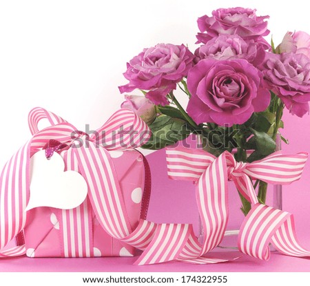 Beautiful gift and roses on pink and white background with copy space for your text here for Mothers Day, International Women\'s Day, female birthday, wedding or loving romantic present.
