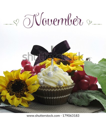 Beautiful Fall Thanksgiving theme cupcake with seasonal flowers and decorations for the month of November with sample text or copy space for your text here.