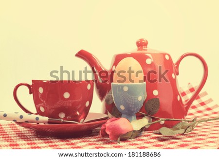 Retro vintage red check Happy Mothers Day or romantic Valentine breakfast with tea cup, tea pot and egg in red and blue polka dot 1950s style china.