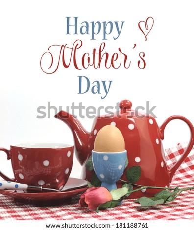 Red theme Happy Mothers Day breakfast in bed with tea cup, tea pot and egg in red and blue polka dot china with sample text or copy space.