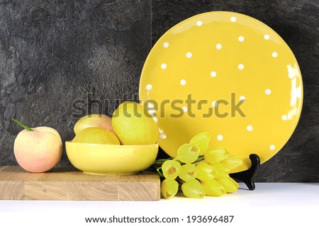 Modern Yellow and White Polka Dot Kitchen with large platter plate, fruit and tulips against black slate and white benchtop.
