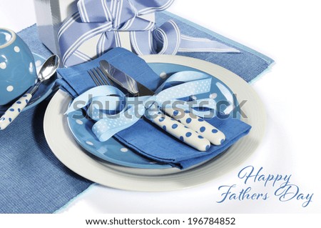 Happy Fathers Day blue theme table setting with gift on white with sample text or copy space for your text here.