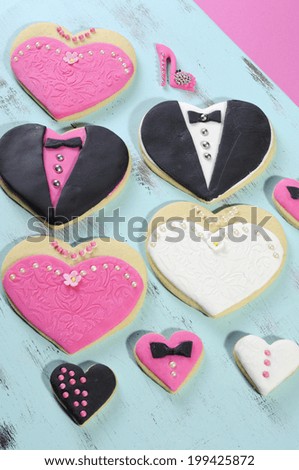 Delicious wedding party bride and groom with bridesmaid and grromsmen pink, white and black heart shape biscuit cookies bridal table favors with mini decorated hearts on a vintage blue tray.